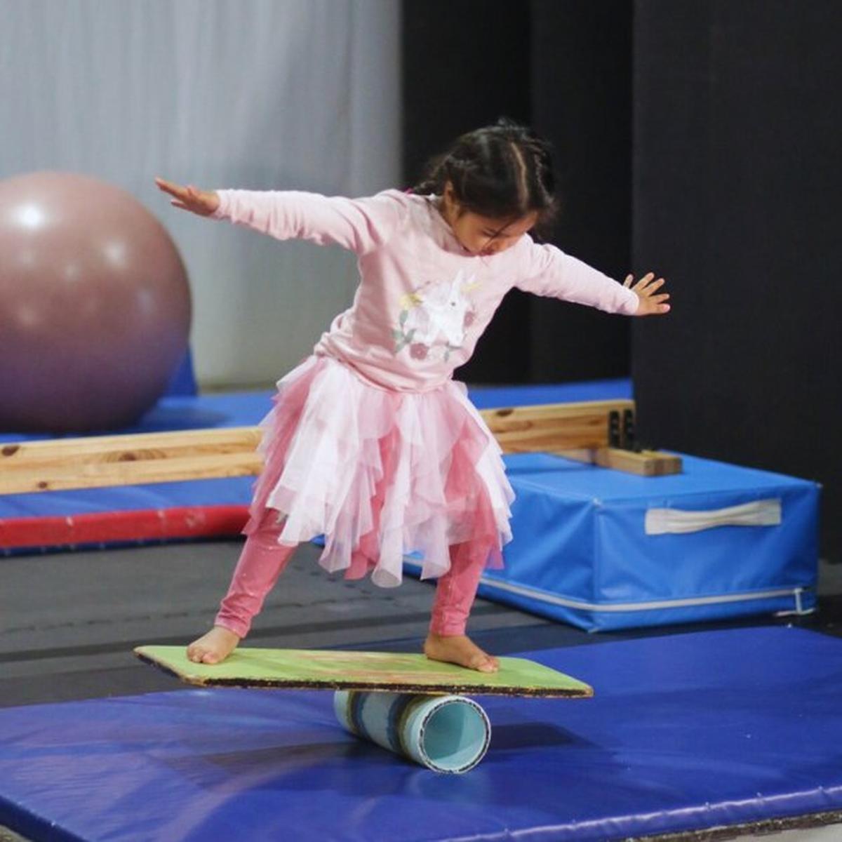 Cirkidz Adelaide, girl in a tutu balancing on a board.