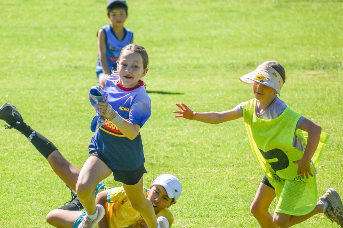 Adelaide University Sport & Fitness - kids running with a ball in on a field.