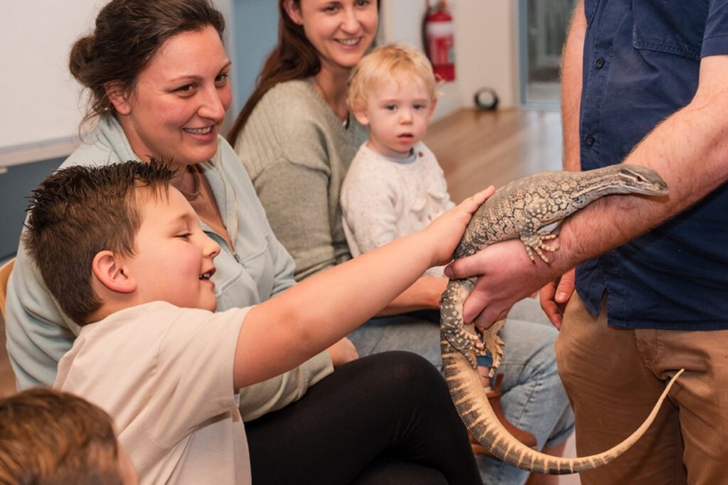 Wilburs Wildlife Sanctury a family interacts with a lizard.