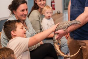 Wilburs Wildlife Sanctury a family interacts with a lizard.