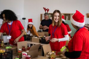 A group of people wearing red shirts and Santa hats, smiling and celebrating together during a festive event.