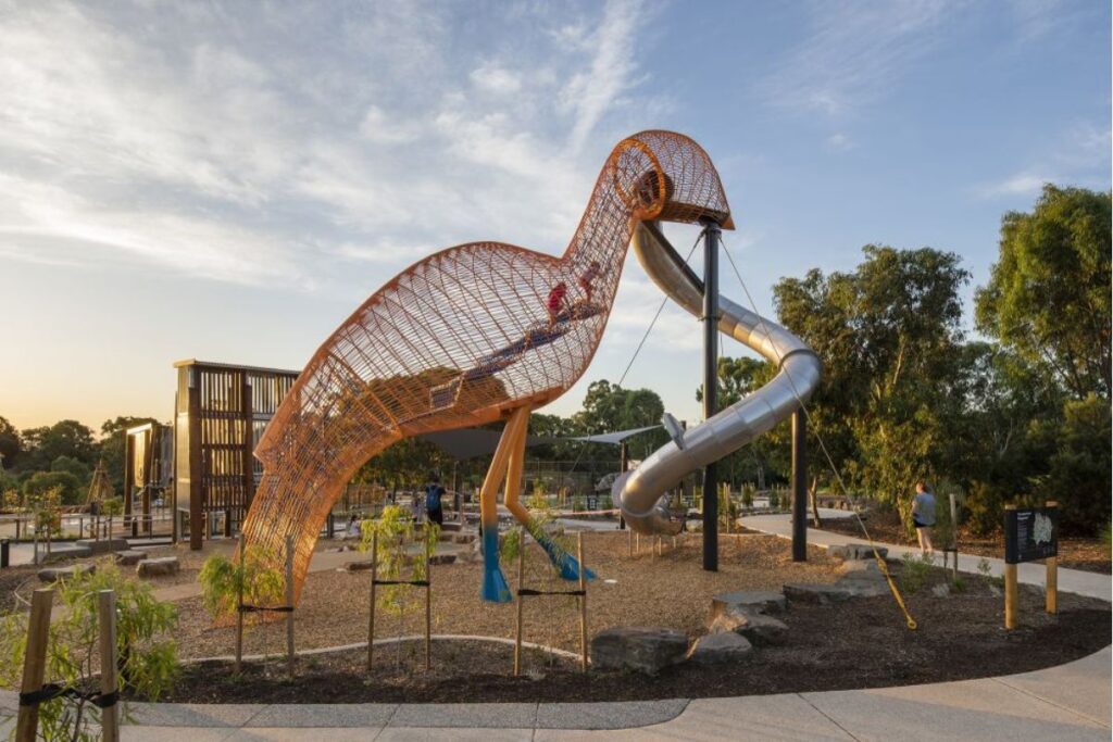 A vibrant playground scene with a tall sculptural slide.