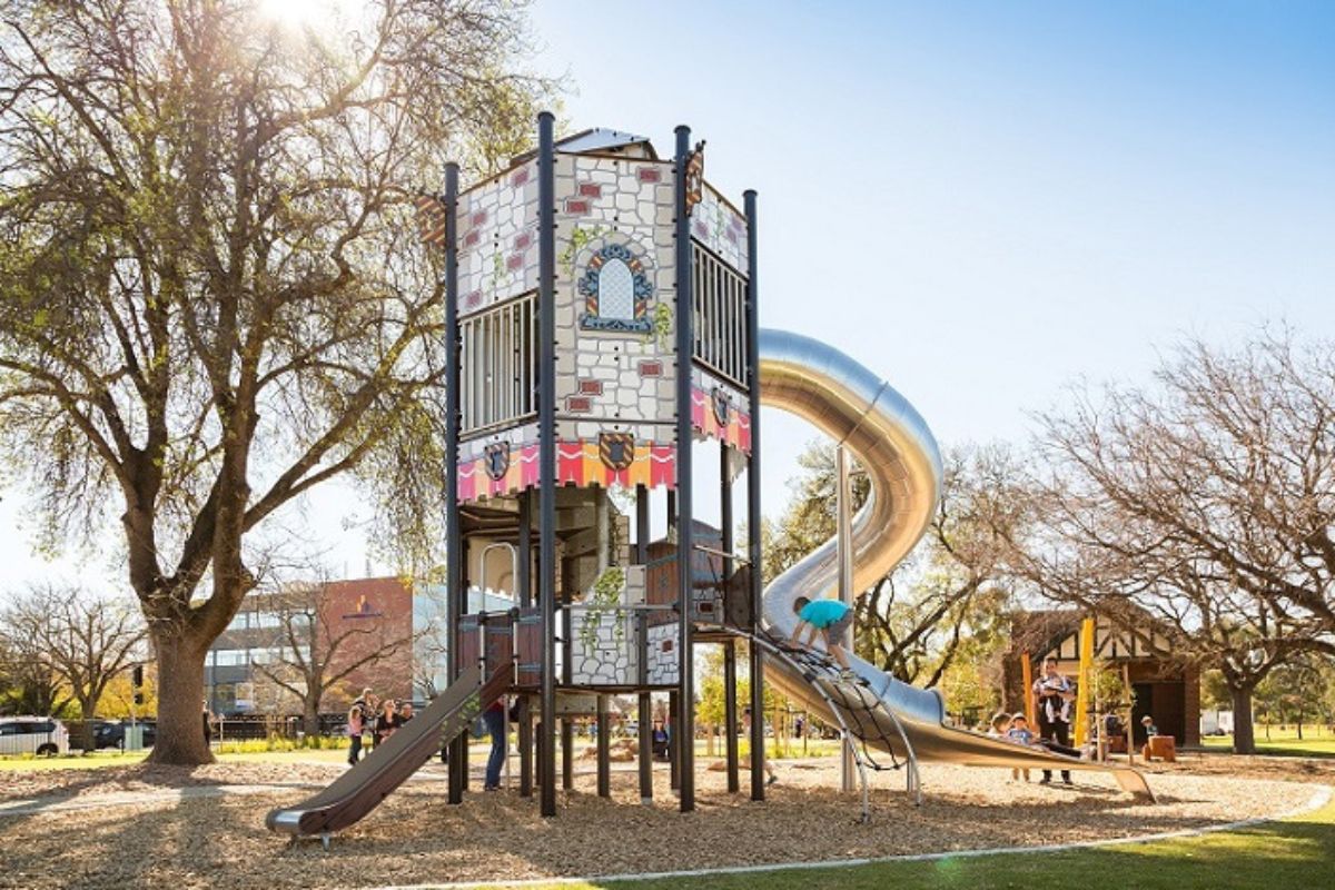 A vibrant playground scene showcasing a slide tower with a slide, designed for children's play and recreation.