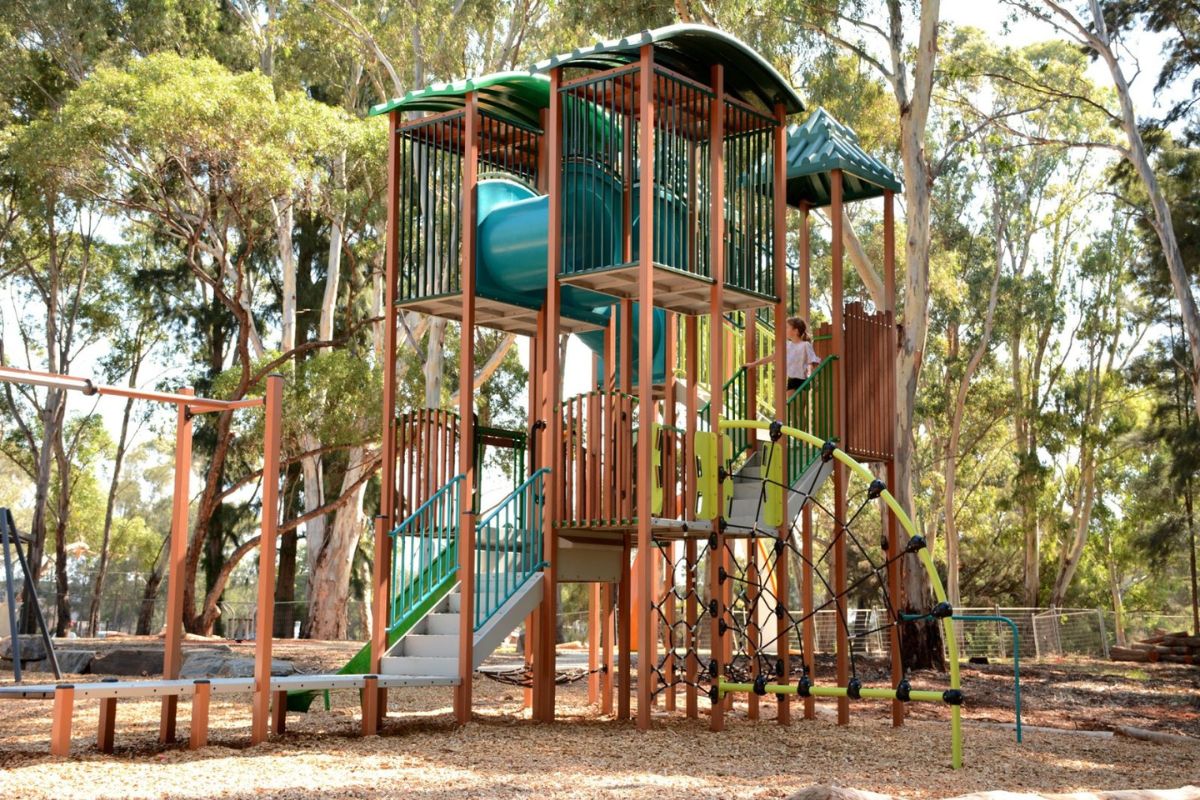 A wooden playground structure featuring a slide and swings, designed for children's outdoor play and recreation.
