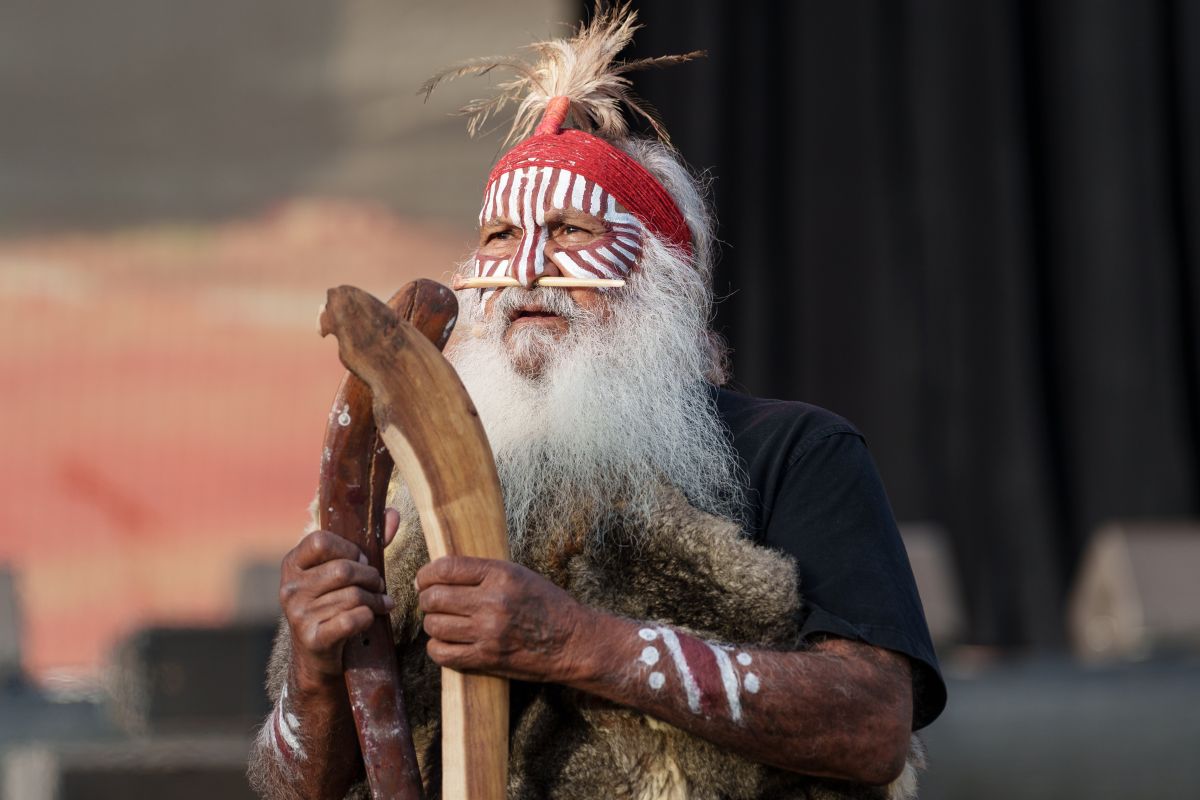 An senior man with a flowing white beard and a vibrant red headdress, reflecting a sense of wisdom, tradition and heritage.