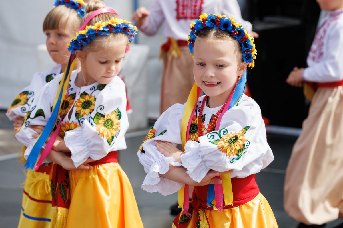 Children in traditional Ukrainian costumes perform a lively dance at the Ukrainian festival, showcasing cultural heritage.