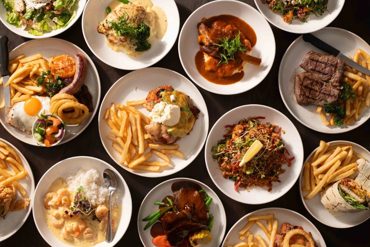 An assortment of plates of food featuring fries and nicely presented main meals