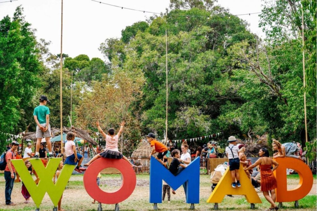 WOMADelaide festival Adelaide botanic gardens. Children climbing on the WOMAD sign in Botanic Park.