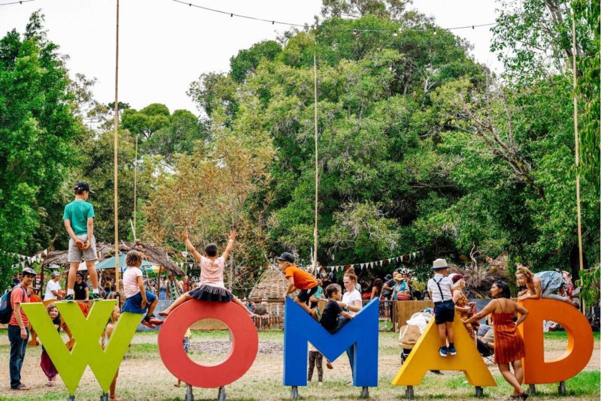 WOMADelaide festival Adelaide botanic gardens. Children climbing on the WOMAD sign in Botanic Park.