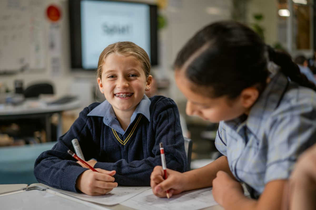 students work happily in a classroom.