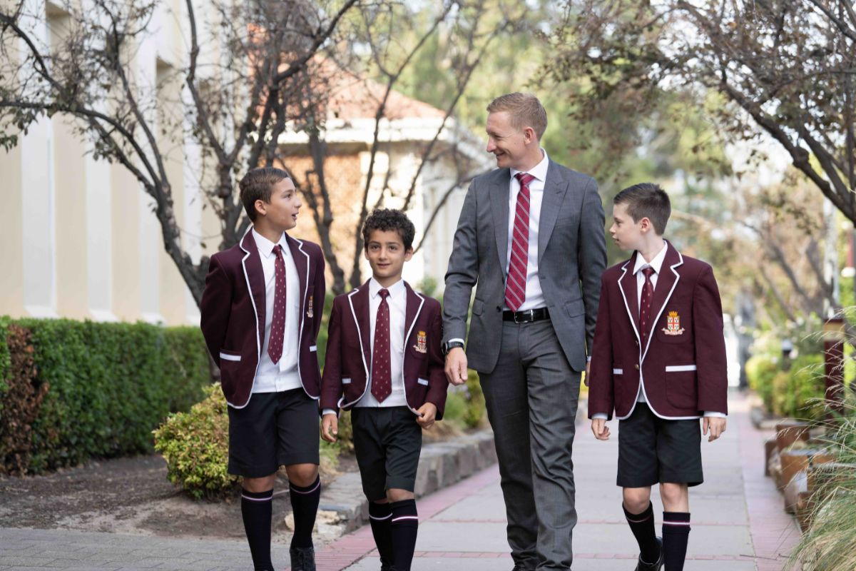 Year 5 Prince Alfred College students walk in the school grounds with a teacher. 