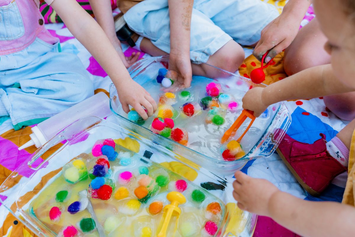children engaged in a craft activity on a colourful blanket