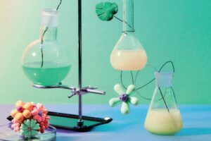 laboratory equipment with different colour liquids and flowers