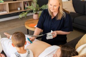 Adelaide Lactation - Megan Goodeve conducting a consultation with a pregnant patient and child sitting beside their mother.