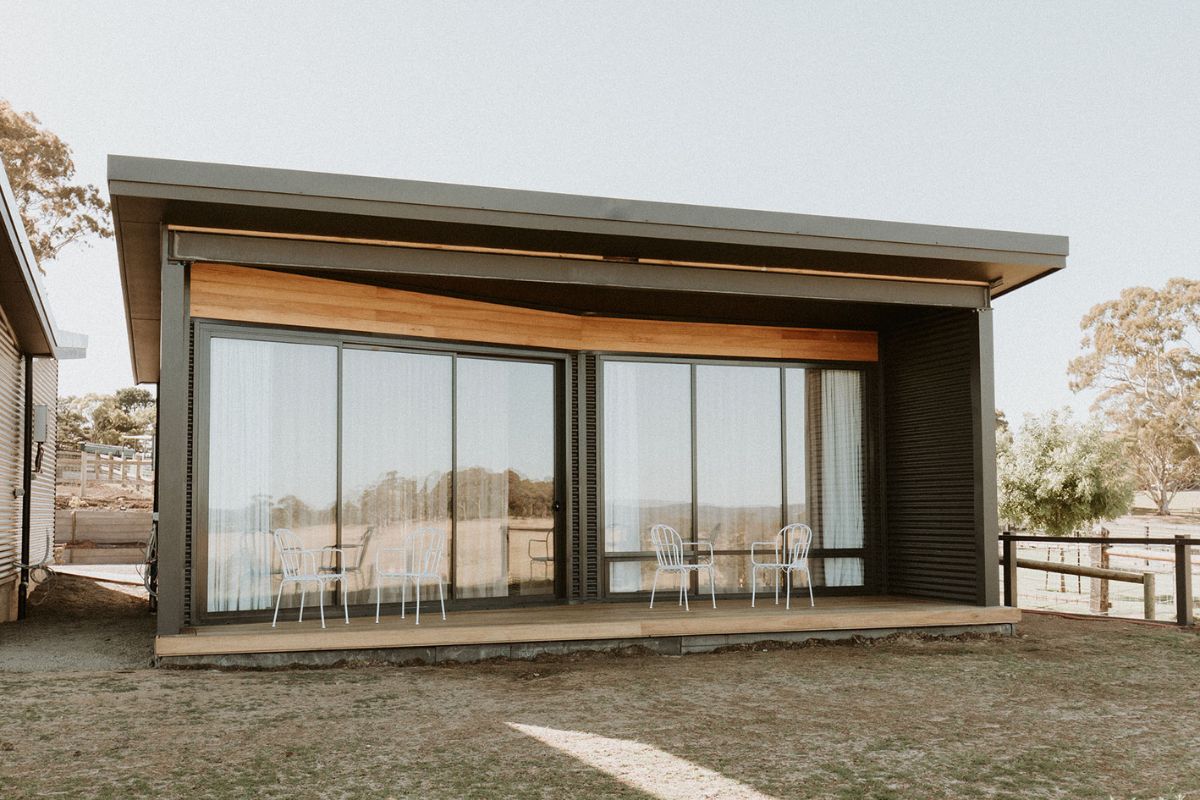Farm Barn. A contemporary home featuring a large glass wall and an inviting patio area.