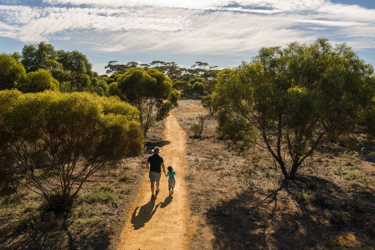A parent and young child walk through Monarto Zoo, South Australia.