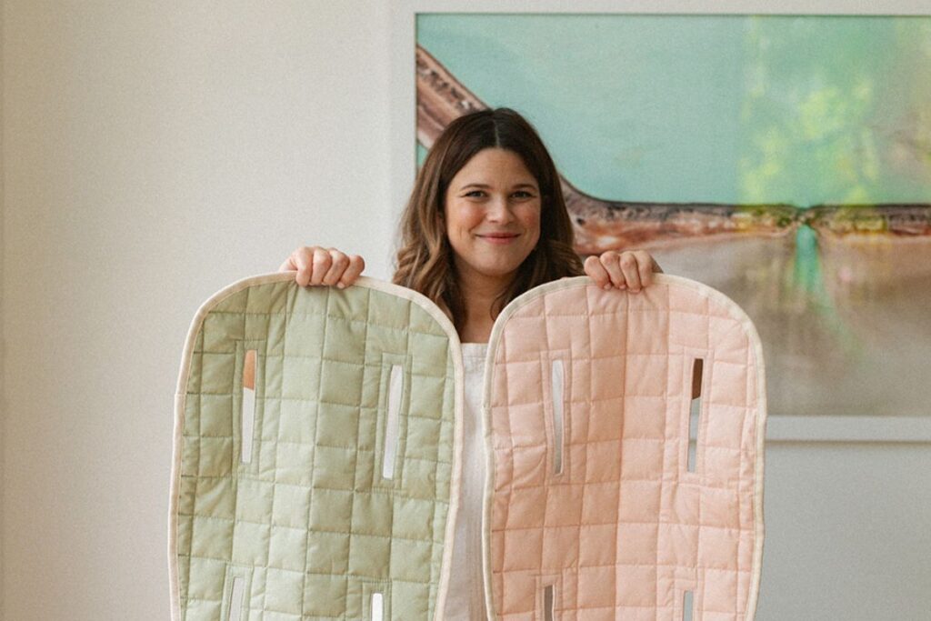 Bubnest Founder Georgia Walker holding up 2 baby pram liners.
