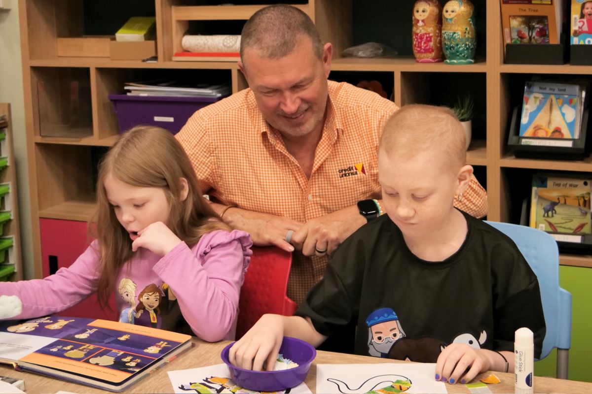 Credit Union SA CEO Todd Roberts joins two Hospital School SA students as they work on their My Art, My SA artworks in the classroom