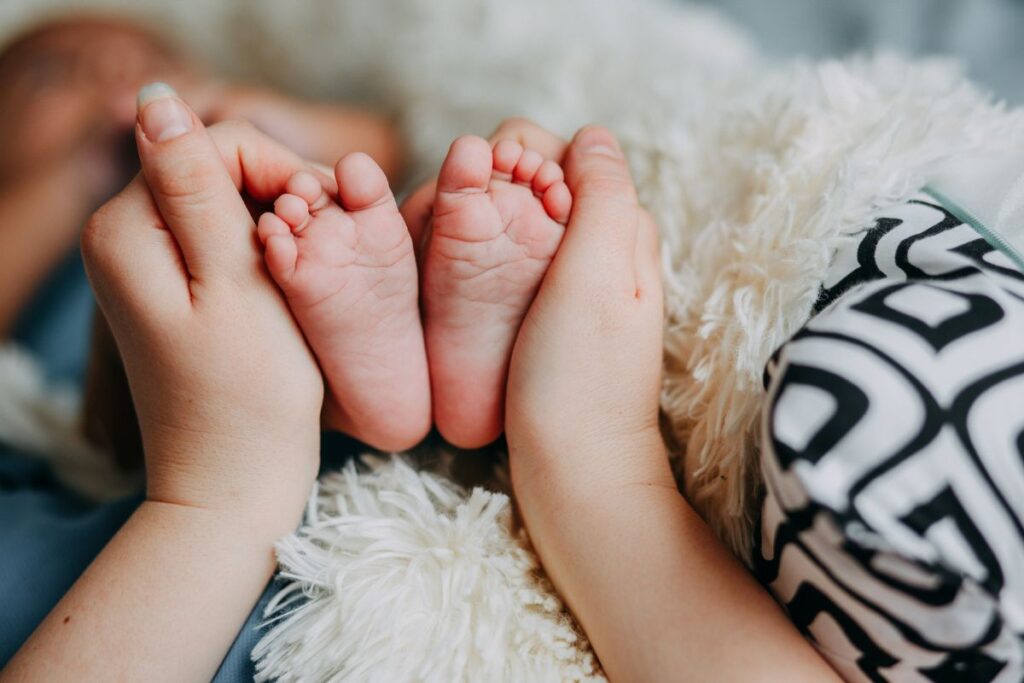 A baby's feet held in a parent's hands.