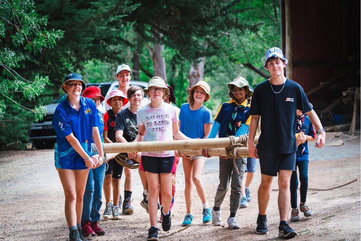 A group of Scouts carrying a canoe.