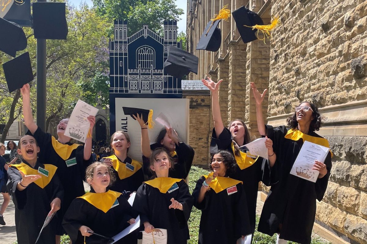 St Mary's College students throw their graduation mortarboards in the air.