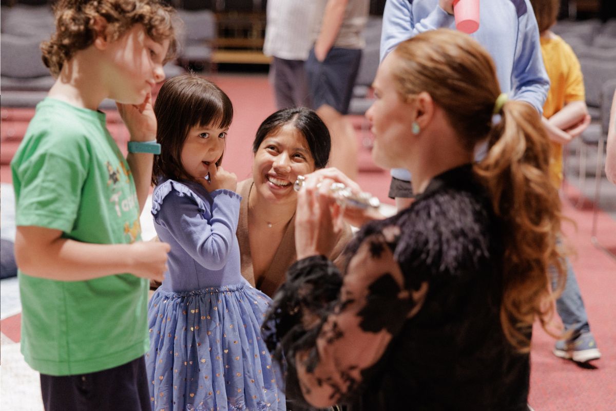 A young child and her mother meet an Adelaide Symphony Orchestra flautist up close after a family concert