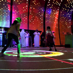 Players competing on an illuminated interactive floor at Augmented Games, Adelaide Showground