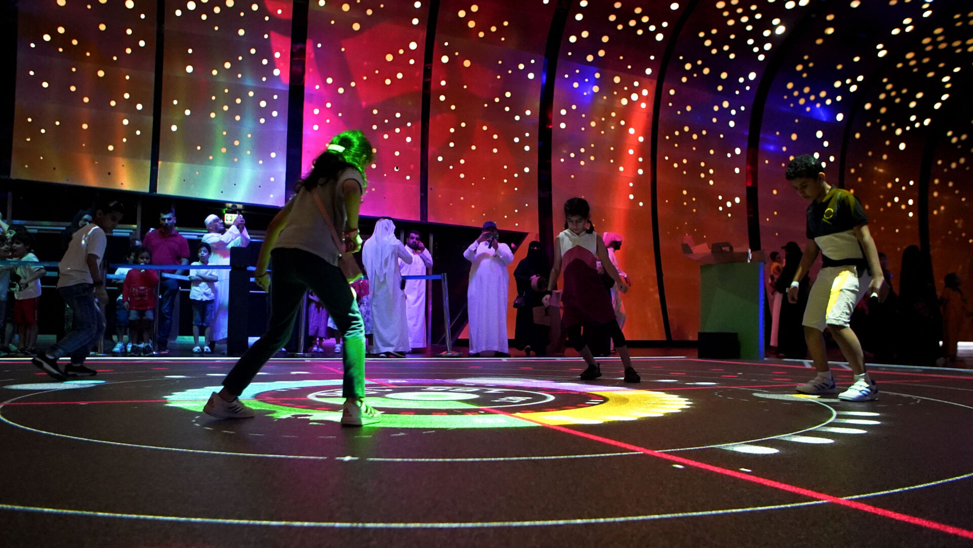 Players competing on an illuminated interactive floor at Augmented Games, Adelaide Showground