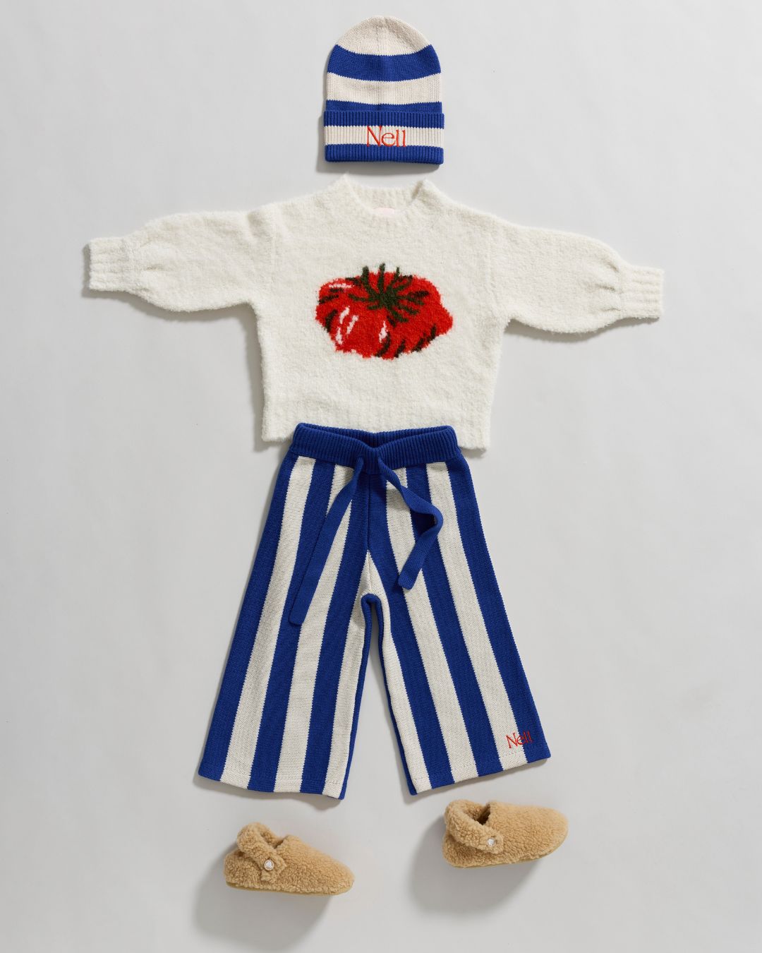 Nell childrens clothing, striped hat and trousers with a white jumper with tomato motif. 