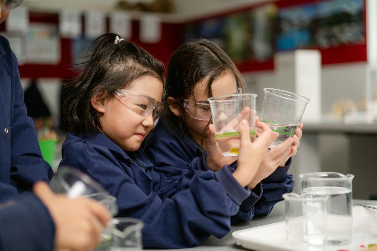 Young Pulteney Grammar Reception students in school uniform performing an experiment