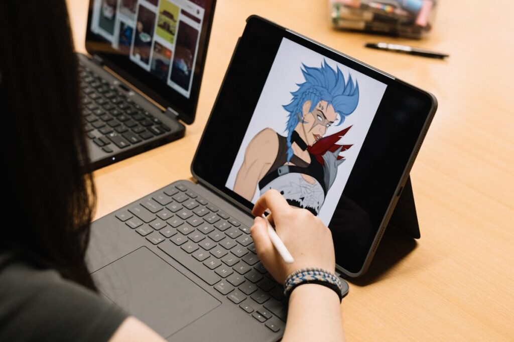 A SASY student using a stylus and tablet to create digital artwork
