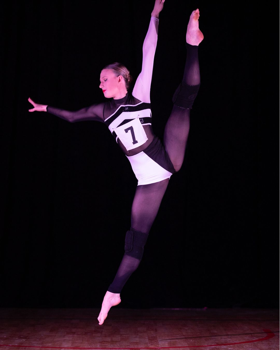 Tatachilla Lutheran College dance students performing a contemporary floor piece under dramatic stage lighting