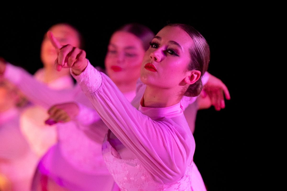 Tatachilla Lutheran College dance students performing a contemporary floor piece under dramatic stage lighting