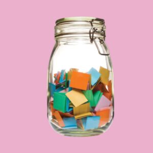Glass jar filled with folded paper strips containing drawing prompts