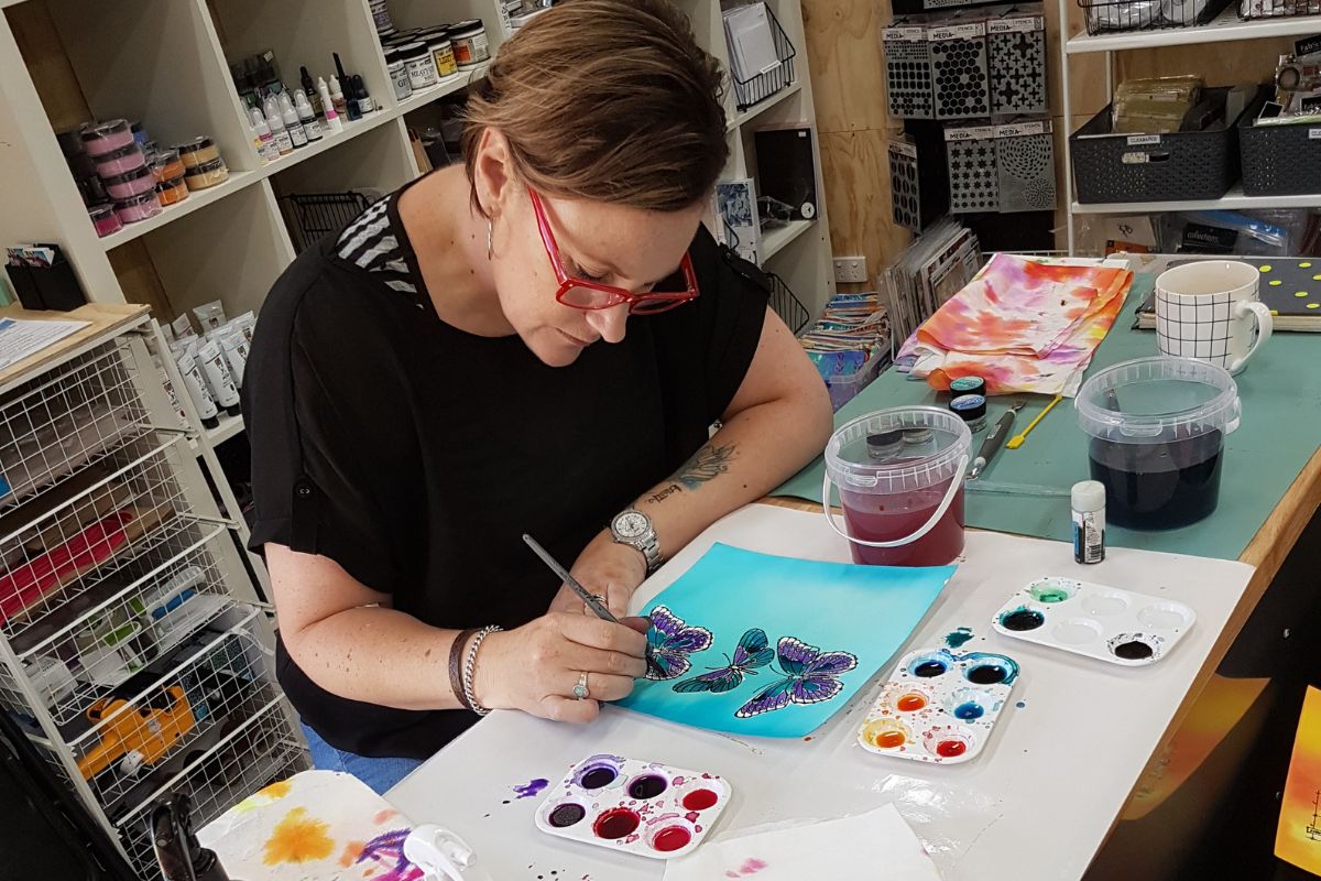Natalie May painting butterflies in watercolour at her craft studio