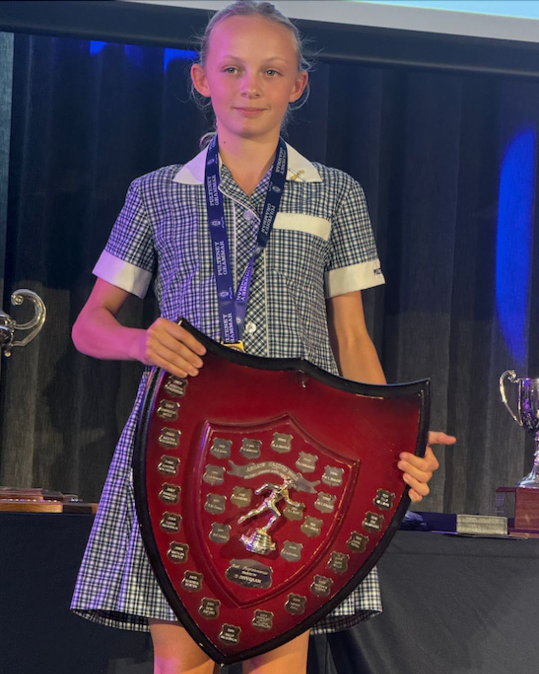 Tilly Williams in Pulteney Grammar School uniform holding an athletics shield