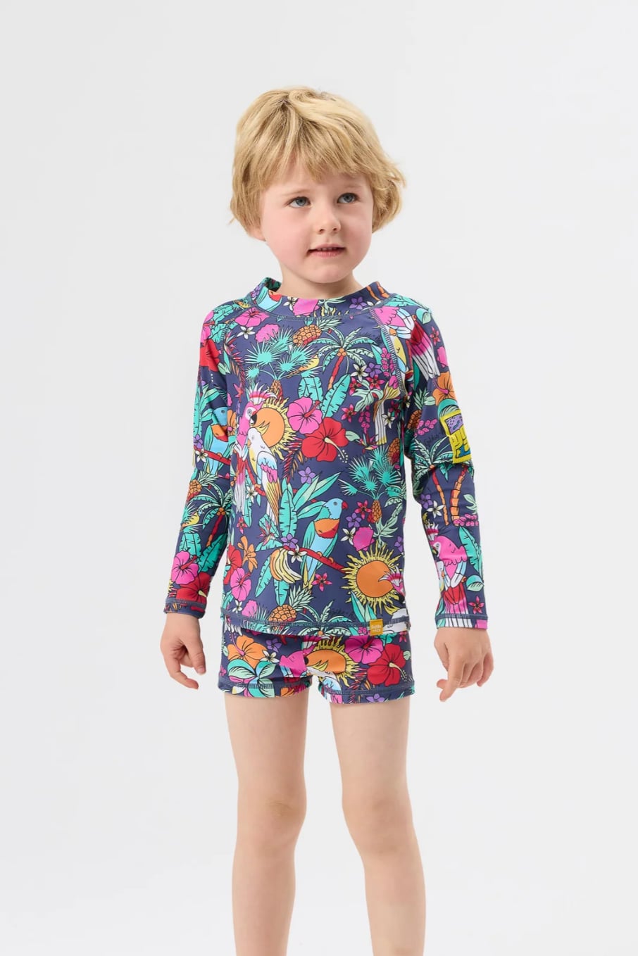Child wearing bright patterned Goldie + Ace rash vest