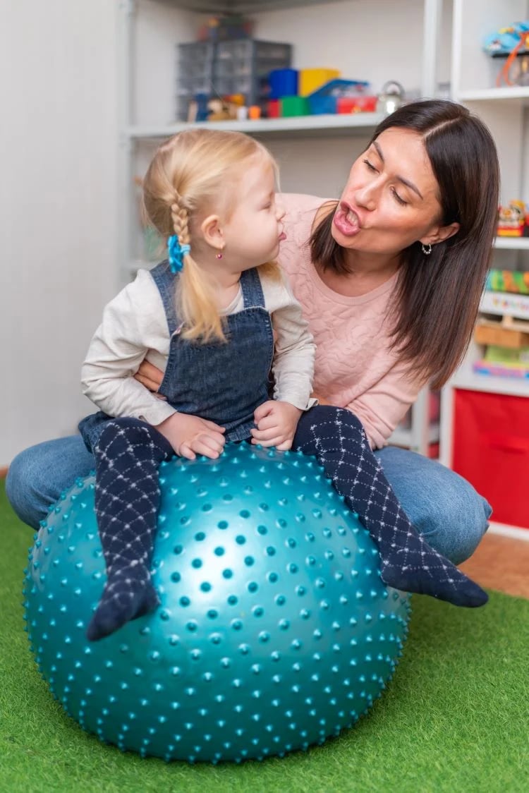 Speech therapist working with young child on speech development